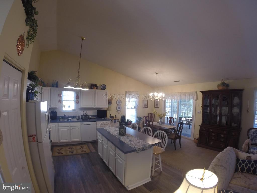 18 Falcon Bridge Road Ocean Pines, MD 21811 - Photo 3 of 21 a kitchen with stainless steel appliances kitchen island granite countertop a refrigerator a stove a sink dishwasher a dining table and chairs with wooden floor