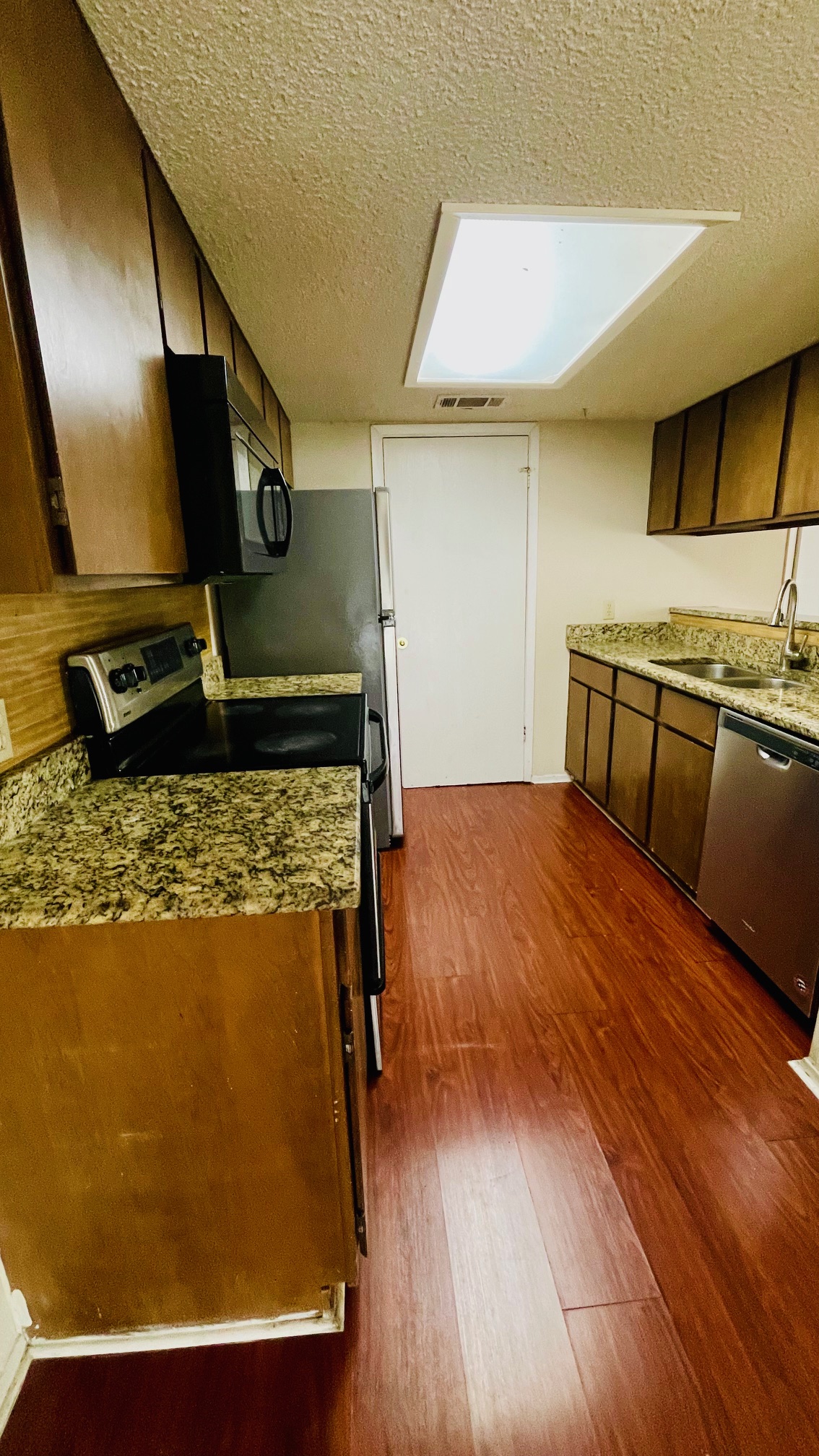 1405 D Camp Craft Road, Unit D West Lake Hills, TX 78746 - Photo 5 of 9 Kitchen featuring stainless steel appliances, a textured ceiling, dark wood-style flooring, and dark wood finish cabinets