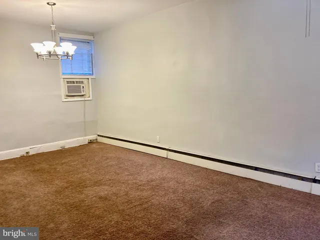 a view of an empty room with chandelier fan
