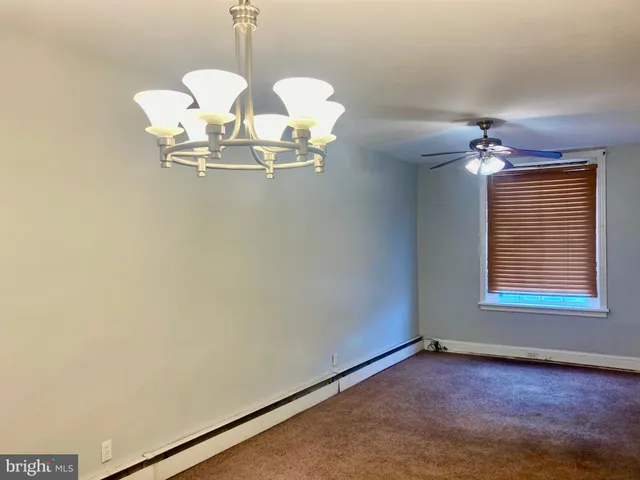 a view of a room with a chandelier fan and windows
