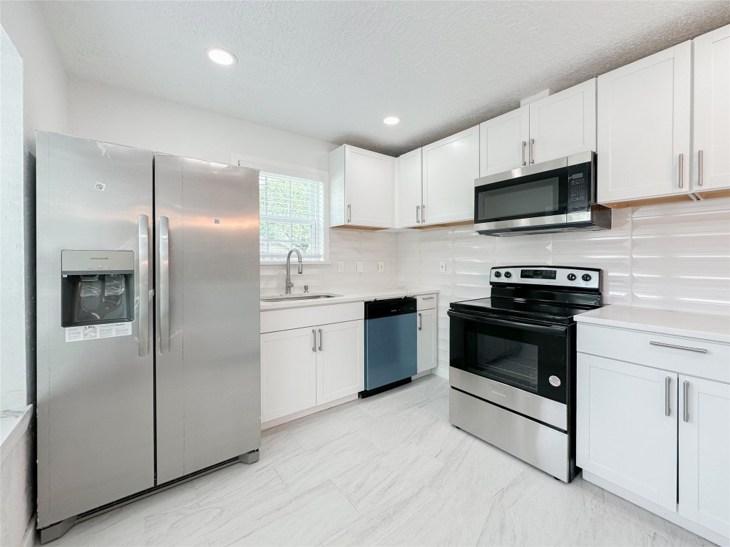 a kitchen with cabinets stainless steel appliances and counter space