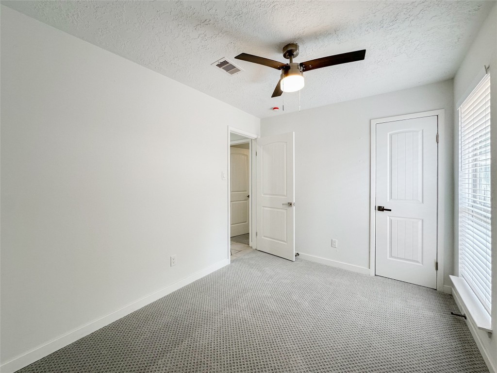 22103 Diane Drive Spring, TX 77373 - Photo 16 of 23 an empty room with a ceiling fan and windows