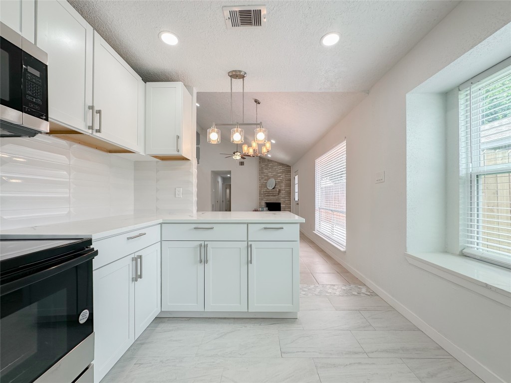 22103 Diane Drive Spring, TX 77373 - Photo 10 of 23 a large white kitchen with granite countertop a stove a sink a dishwasher and white cabinets with wooden floor