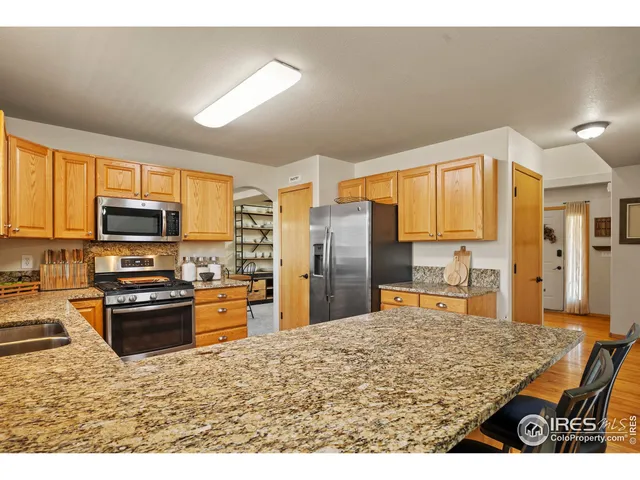 a kitchen with stainless steel appliances granite countertop a stove refrigerator sink and dishwasher