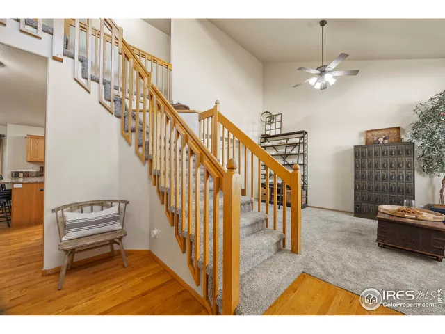 a view interior of a house with wooden floor stairs and a chandelier fan