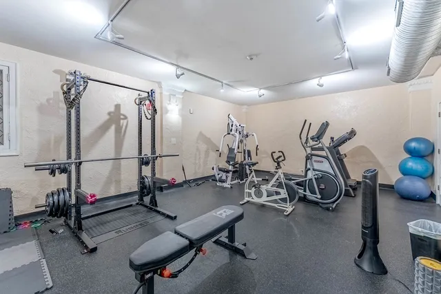 a kitchen with a sink a stove a refrigerator and white cabinets
