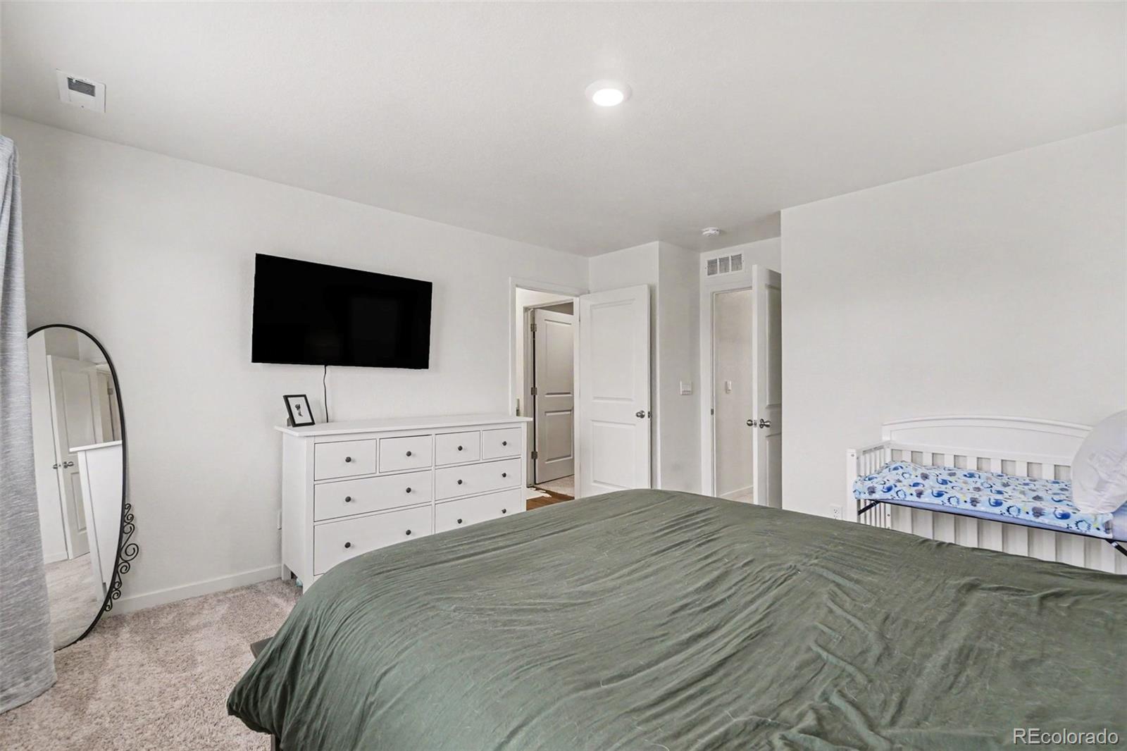 7008 Kali Court Frederick, CO 80530 - Photo 13 of 28 a bedroom with a bed tv and a mirror