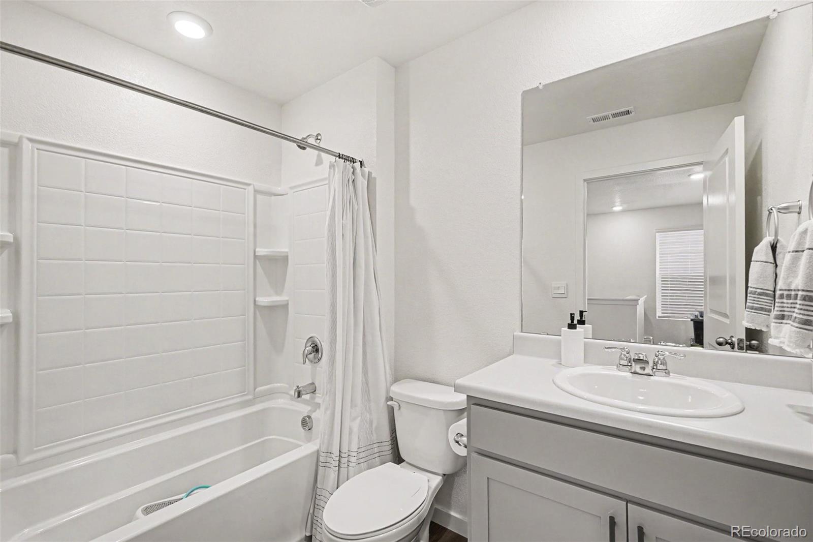 7008 Kali Court Frederick, CO 80530 - Photo 17 of 28 a bathroom with a sink toilet vanity and shower