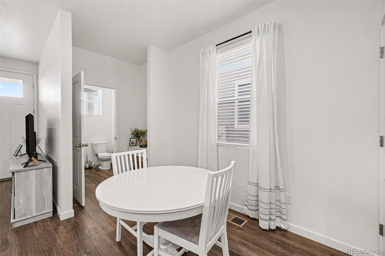7008 Kali Court Frederick, CO 80530 - Photo 6 of 28 a view of a dining room with furniture window and wooden floor