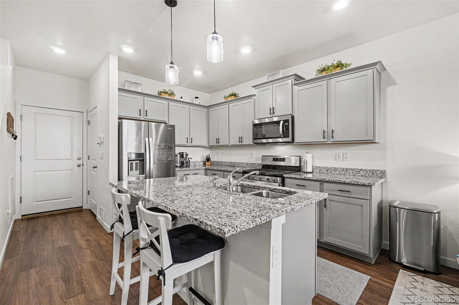 7008 Kali Court Frederick, CO 80530 - Photo 9 of 28 a kitchen with stainless steel appliances granite countertop a stove refrigerator sink and cabinets