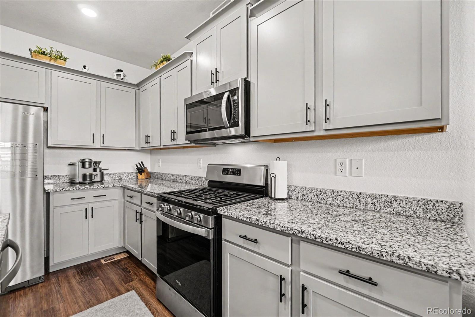 7008 Kali Court Frederick, CO 80530 - Photo 10 of 28 a kitchen with granite countertop white cabinets white stainless steel appliances and a sink