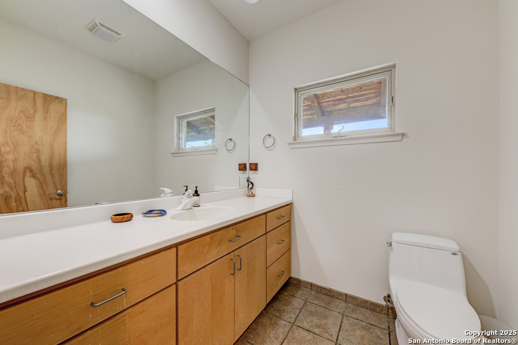 306 Fieldstone Johnson City, TX 78636 - Photo 12 of 31 a bathroom with a sink mirror vanity and toilet