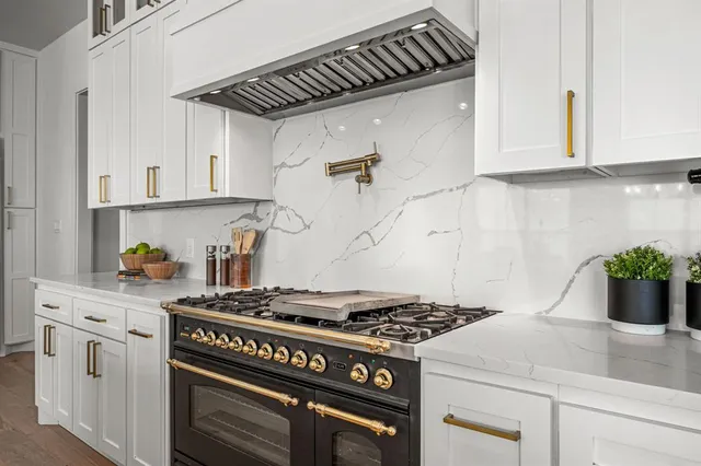a kitchen with granite countertop stainless steel appliances and white cabinets
