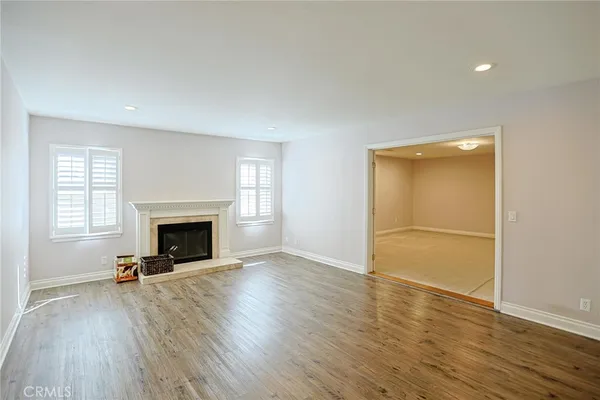 a view of an empty room with wooden floor and closet