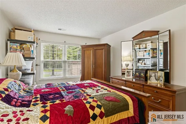 a bedroom with a bed and large windows