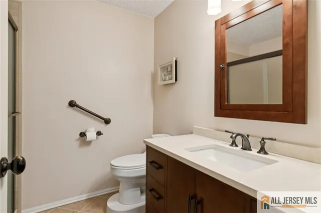 a bathroom with a granite countertop sink a toilet and a mirror