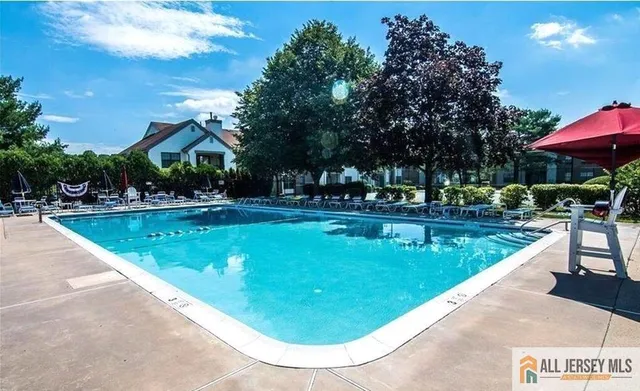 a view of a swimming pool with a chair and tables in the patio