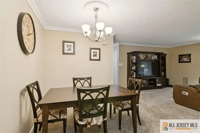 a view of a dining room with furniture and a chandelier