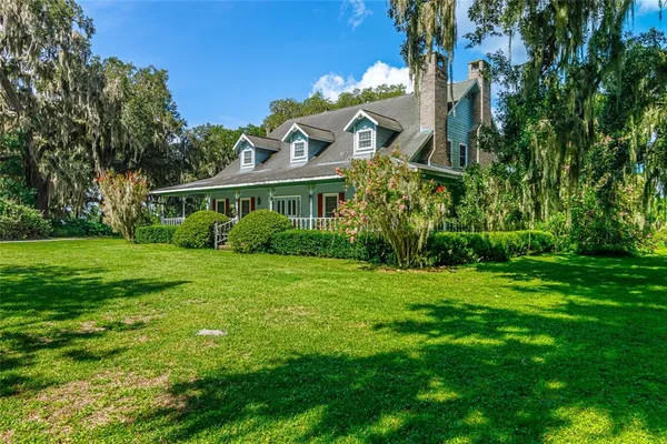 a kitchen with stainless steel appliances granite countertop a refrigerator a sink dishwasher a stove and a dining table with wooden floor