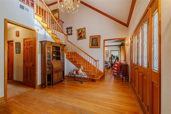 a dining room with furniture a chandelier and wooden floor