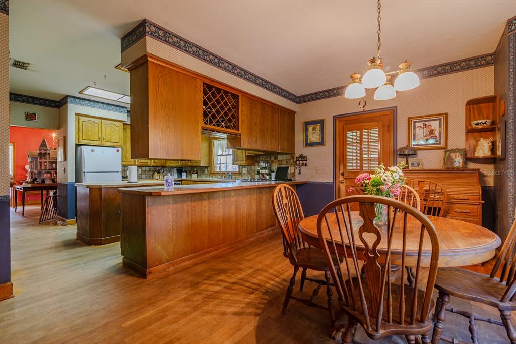 15795 Northwest 86th Avenue Reddick, FL 32686 - Photo 40 of 83 a dining room with furniture a chandelier and wooden floor