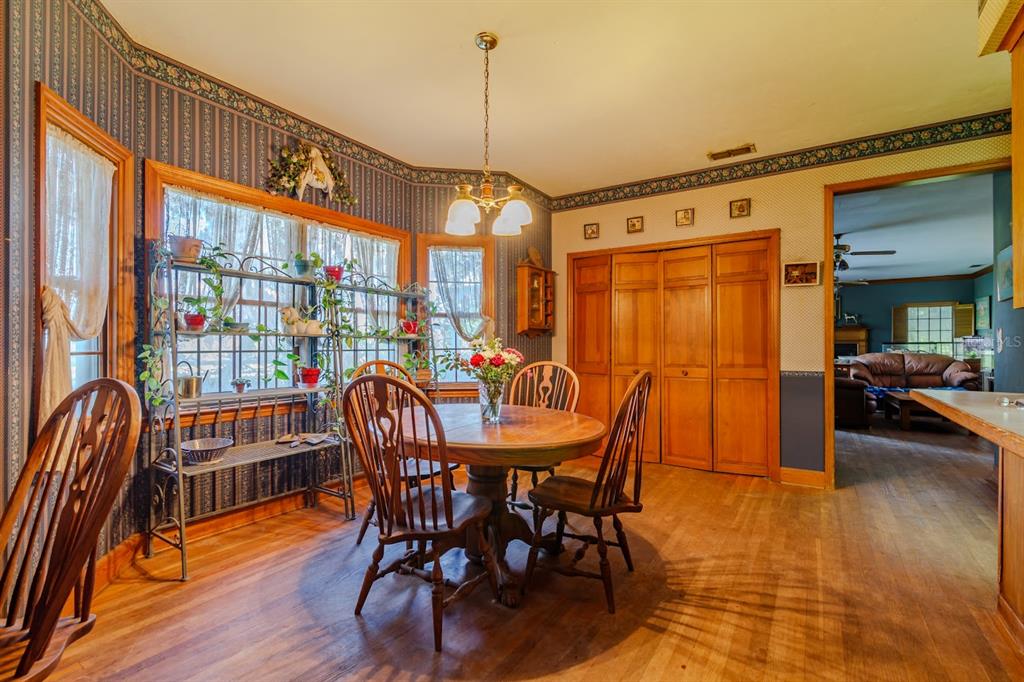15795 Northwest 86th Avenue Reddick, FL 32686 - Photo 41 of 83 a dining room with furniture a chandelier and wooden floor