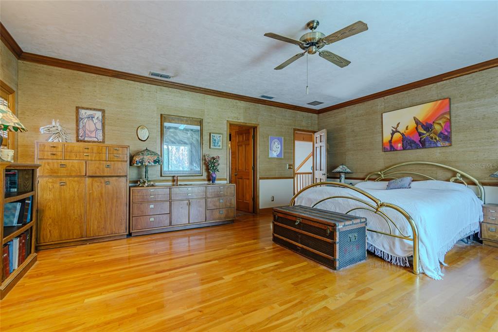 15795 Northwest 86th Avenue Reddick, FL 32686 - Photo 48 of 83 a spacious bedroom with a bed and a chandelier
