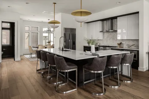 a kitchen with stainless steel appliances a dining table chairs and wooden floor