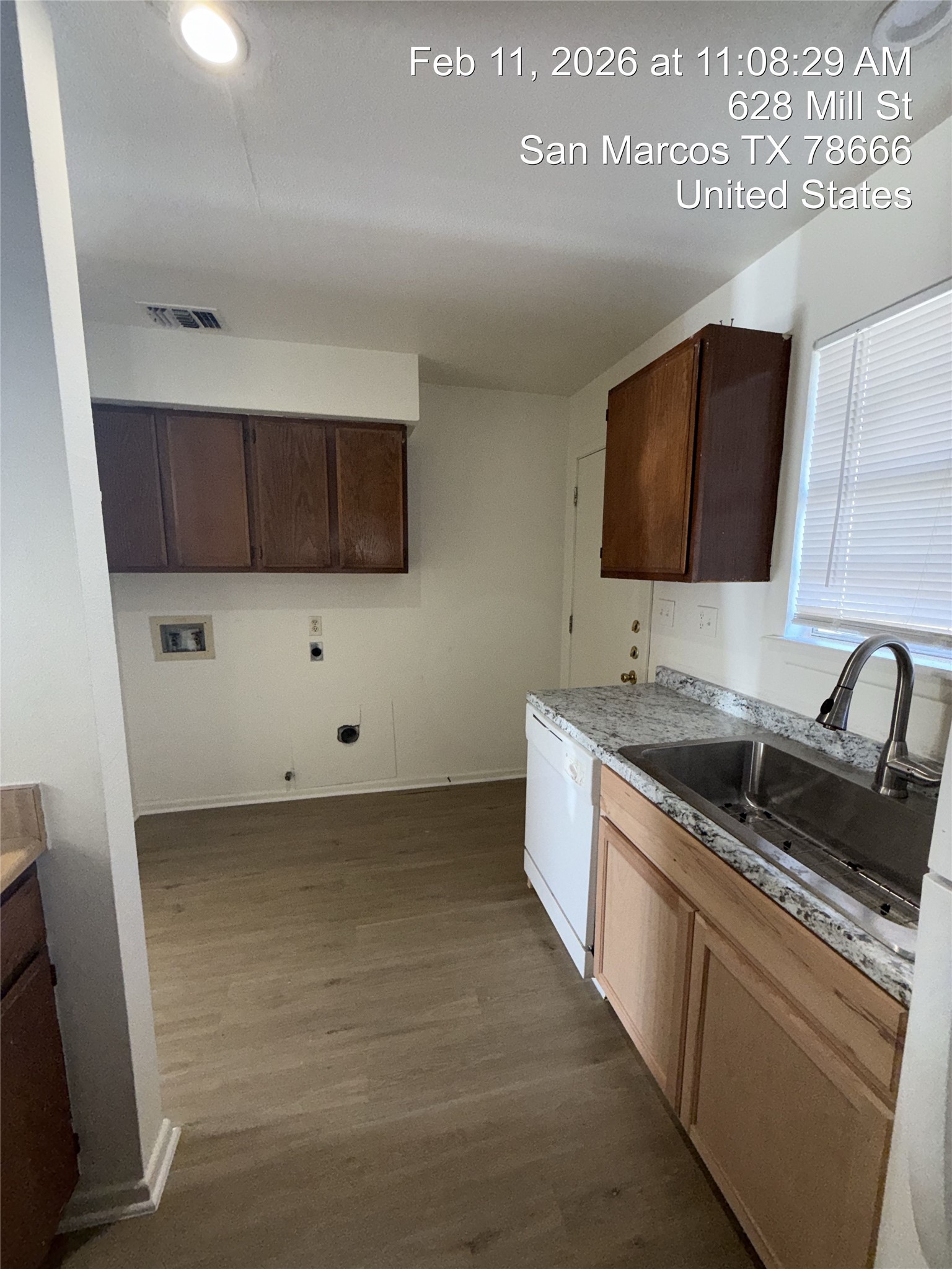 628 Mill Street, Unit B San Marcos, TX 78666 - Photo 3 of 13 Kitchen with dark wood-style floors, white dishwasher, dark wood finish cabinets, and light stone countertops