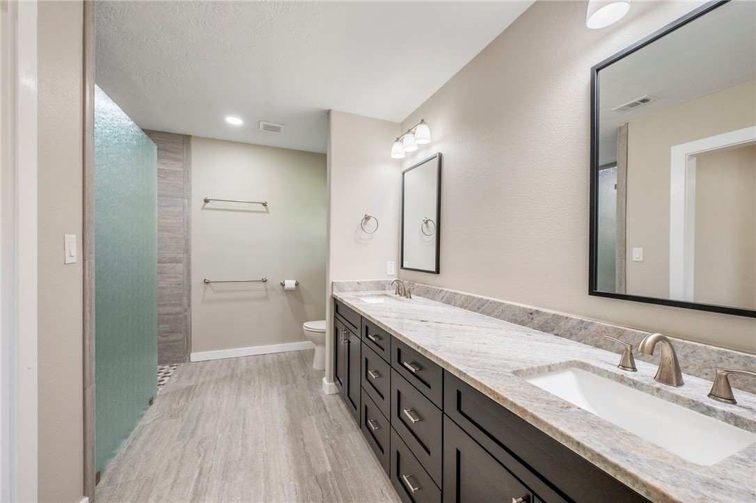 304 Dunn Street Bryan, TX 77801 - Photo 12 of 29 Primary bathroom featuring double vanity, granite