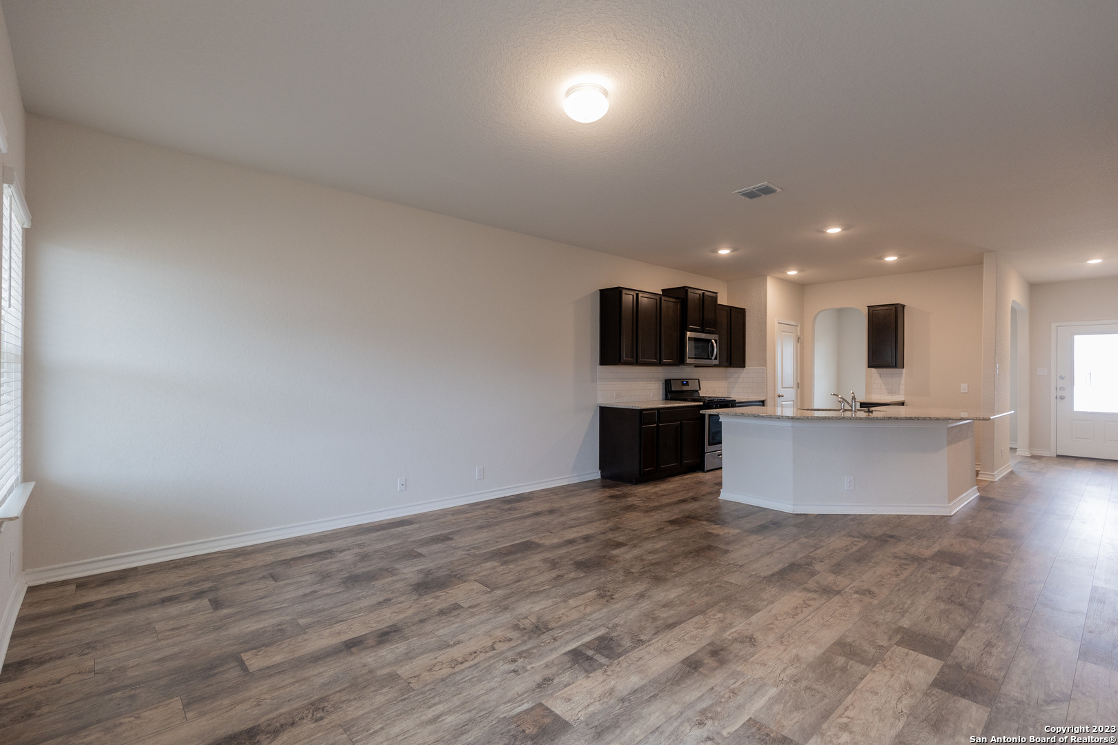9819 Bratten Rise San Antonio, TX 78254 - Photo 7 of 37 an open kitchen with kitchen island microwave and stove top oven
