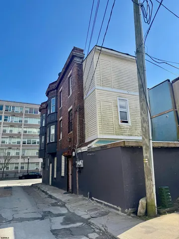 a backyard of a house with barbeque oven and outdoor seating