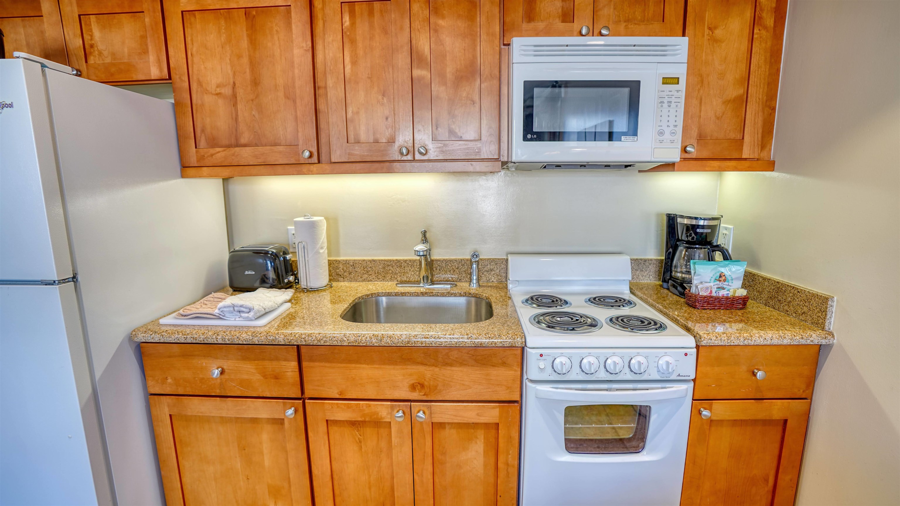 4365 Lower Honoapiilani Road, Unit 1018 Lahaina, HI 96761 - Photo 8 of 35 a kitchen with a stove sink and cabinets