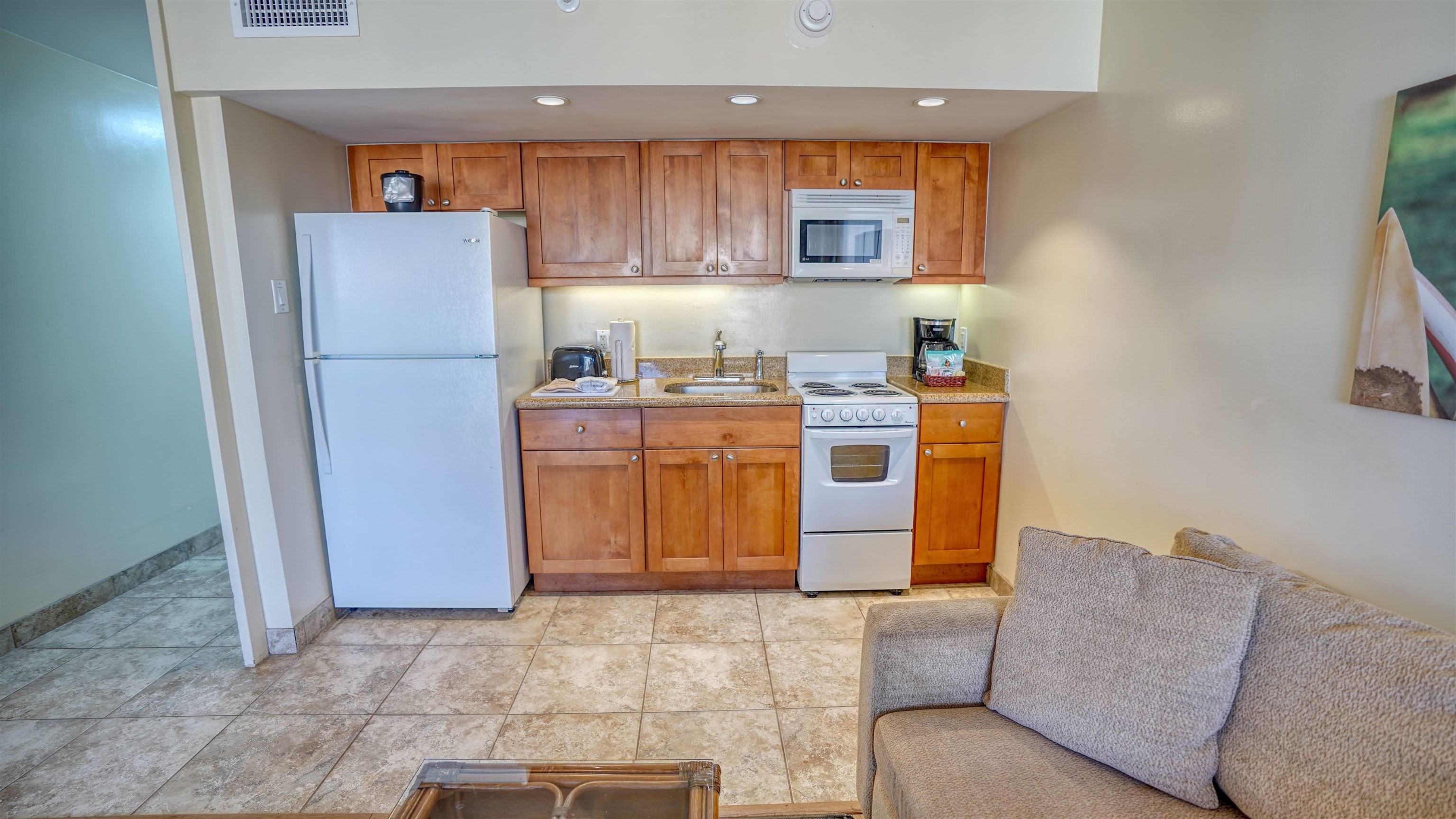 4365 Lower Honoapiilani Road, Unit 1018 Lahaina, HI 96761 - Photo 10 of 35 a kitchen with stainless steel appliances granite countertop a refrigerator sink stove and microwave