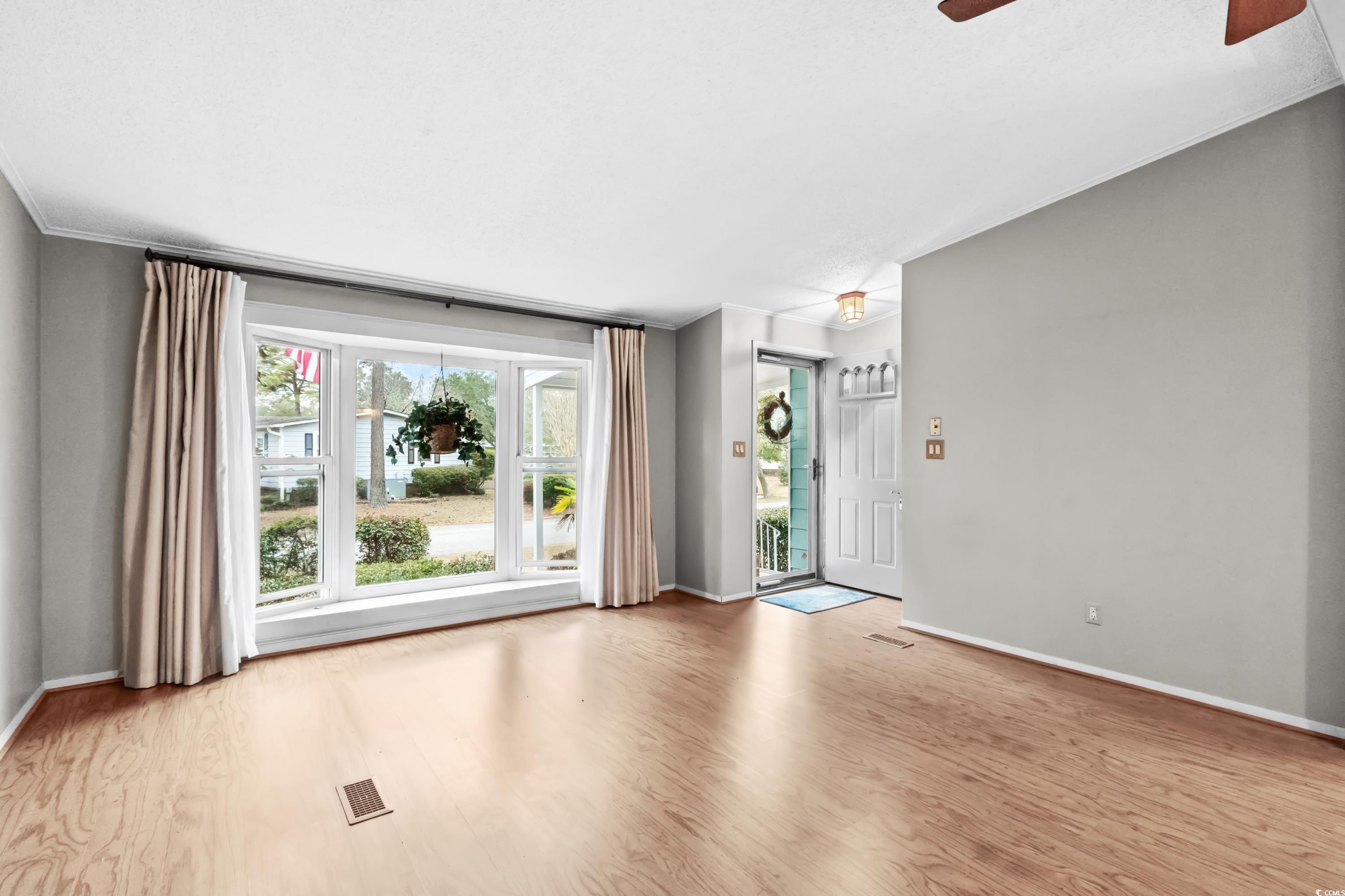 808 Carolina Drive Murrells Inlet, SC 29576 - Photo 6 of 40 Empty room with ceiling fan and light wood-type fl