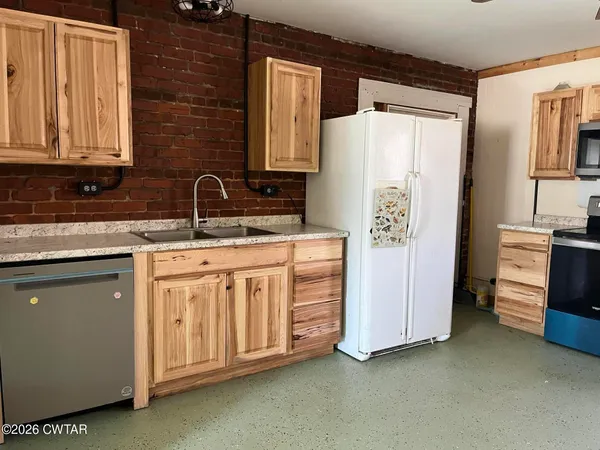 a kitchen with stainless steel appliances a refrigerator sink and cabinets