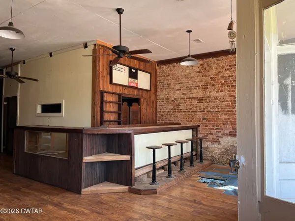 a hallway with a stove a microwave oven and a dining table with wooden floor