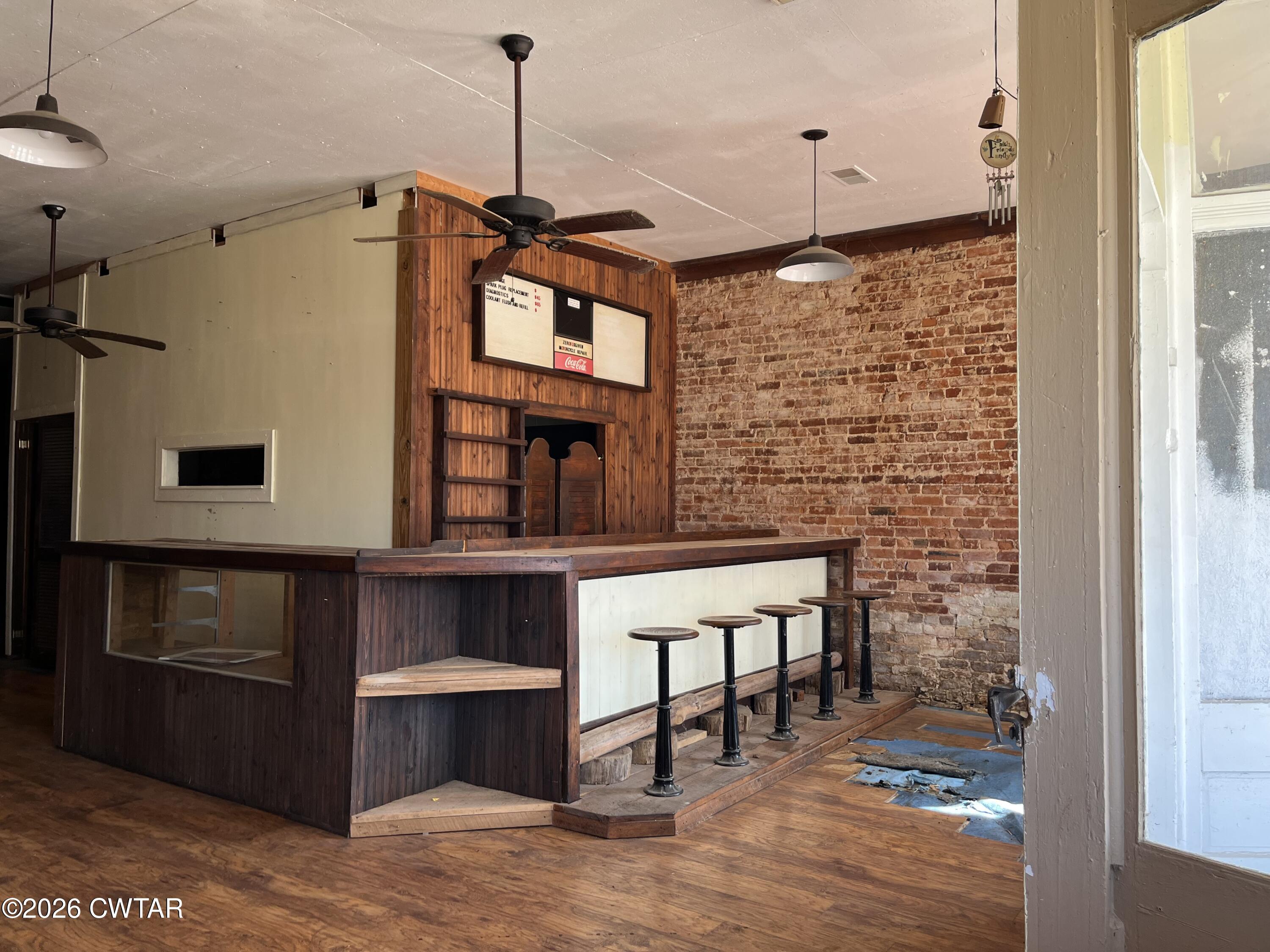 1693 Highway 138 Mercer, TN 38392 - Photo 7 of 10 a hallway with a stove a microwave oven and a dining table with wooden floor