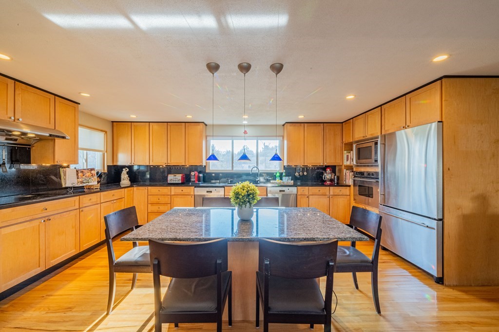 4 Springdale Road Lexington, MA 02421 - Photo 15 of 42 a kitchen with stainless steel appliances a dining table chairs refrigerator and sink