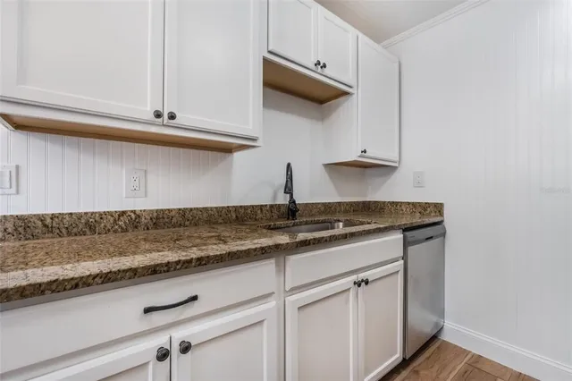 a kitchen with stainless steel appliances granite countertop a sink and a white cabinets