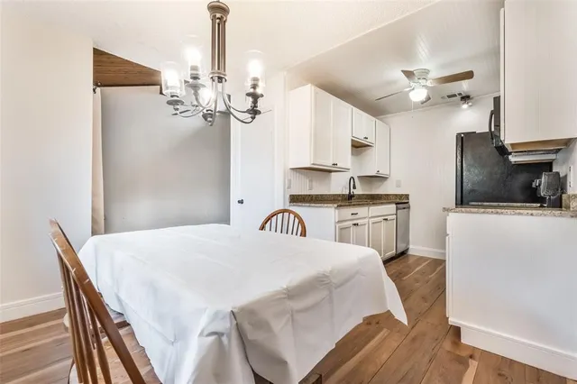 a kitchen with granite countertop a table chairs stainless steel appliances and cabinets