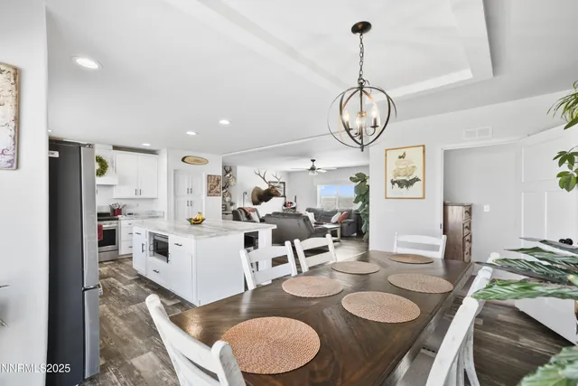 a view of a dining room and livingroom with furniture wooden floor a chandelier