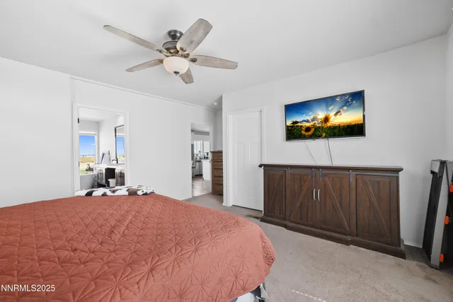a bedroom with a bed and a ceiling fan