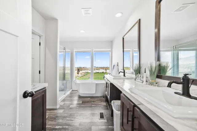 a bathroom with a double vanity sink window and a bathtub