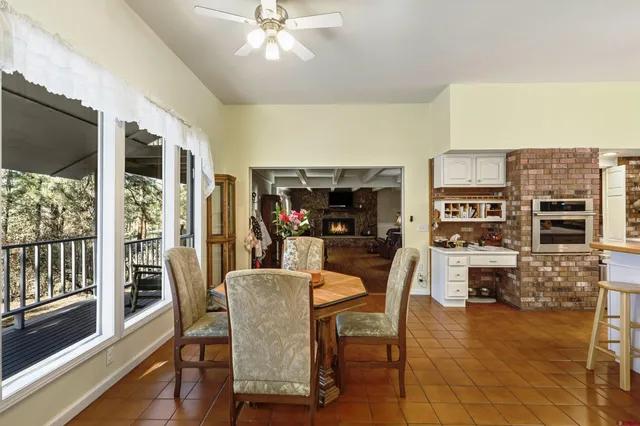 a kitchen with stainless steel appliances granite countertop a sink a stove a refrigerator cabinets and chairs