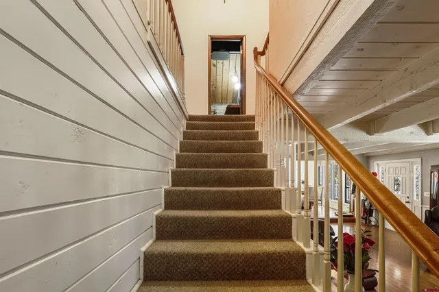 a view of a hallway with wooden floor and staircase