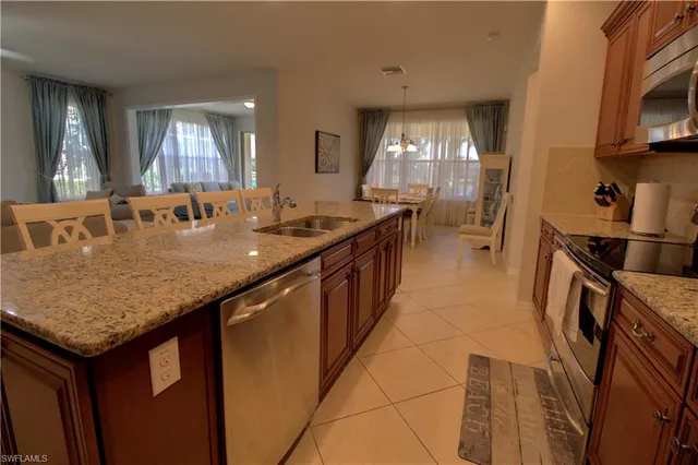 a kitchen with kitchen island granite countertop a sink a counter top space and cabinets