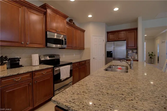 a kitchen with stainless steel appliances granite countertop a stove sink and cabinets