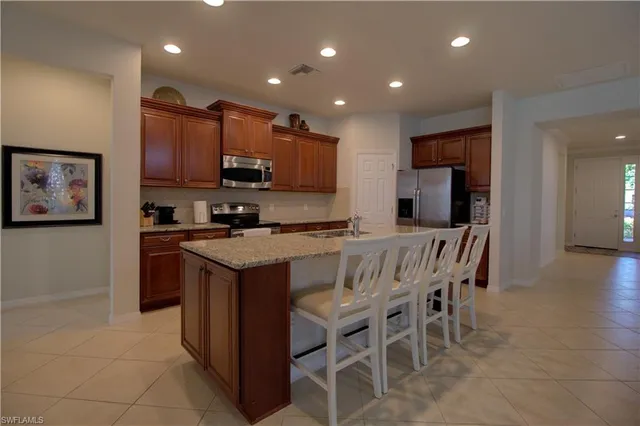 a kitchen with stainless steel appliances granite countertop a stove a sink a refrigerator and a microwave
