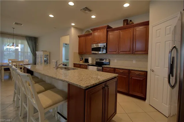 a kitchen with stainless steel appliances granite countertop a sink refrigerator and cabinets